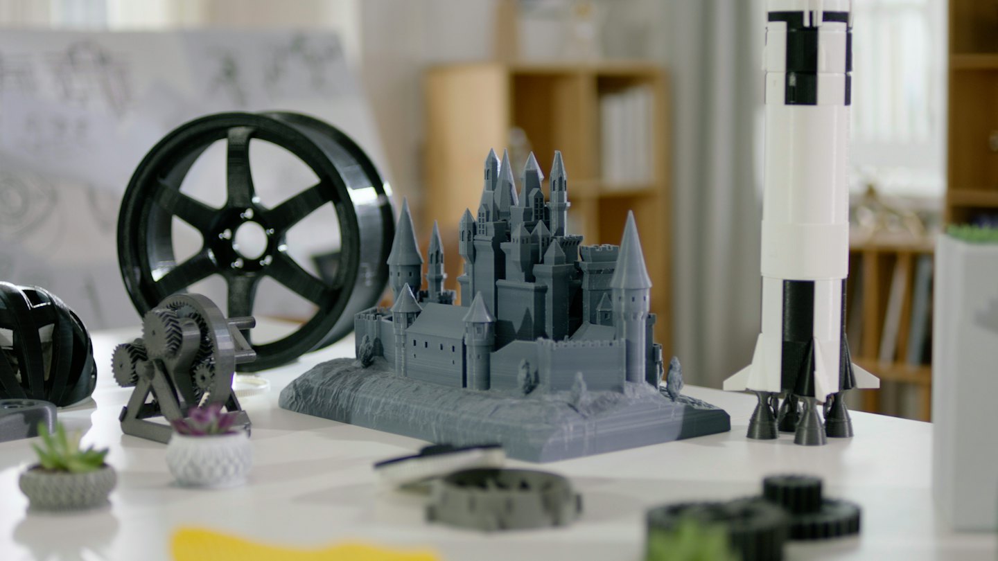 Olika 3D-printade objekt på ett vitt bord.